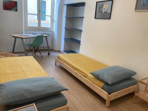 a room with two beds and a desk and a table at La casa di Toni 2 passi dal mare in Finale Ligure