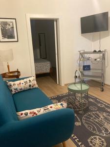 a living room with a blue couch and a table at La casa di Toni 2 passi dal mare in Finale Ligure