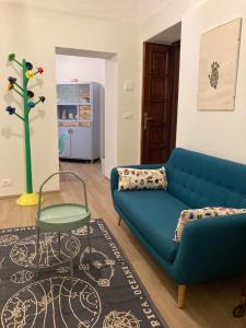 a living room with a blue couch and a table at La casa di Toni 2 passi dal mare in Finale Ligure
