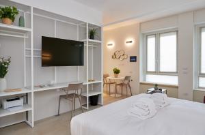 a bedroom with a bed and a desk and a tv at Gioia 55 in Milan
