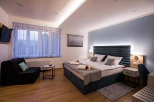 una camera con un grande letto e una sedia di Klečka vila B&B rooms a Ogulin