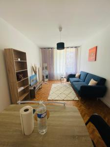 een woonkamer met een blauwe bank en een tafel bij Appartement T4 Madoumier in Limoges