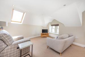 a living room with two chairs and a tv at Bay View Apartments in Port Erin