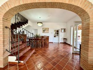 einen Torbogen in einem Haus mit einer Treppe und einem Esszimmer in der Unterkunft Villa San Bartolo in San Vincenzo