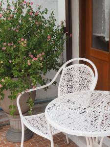 two white chairs and a table and a potted plant at Cozy House in Middle of Old Town Chiangmai in Chiang Mai