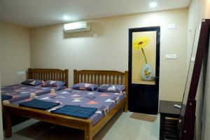 a bedroom with two beds and a painting of a flower at Hangout in Kalyānpur