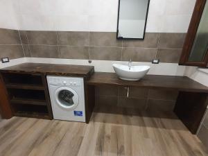 La salle de bains est pourvue d'un lavabo et d'un lave-linge. dans l'établissement Appartamento vacanza mare nel centro di Brolo, à Brolo