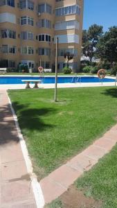 eine Rasenfläche mit einem Pool und einem Gebäude in der Unterkunft Apartamento con vistas al mar in Málaga