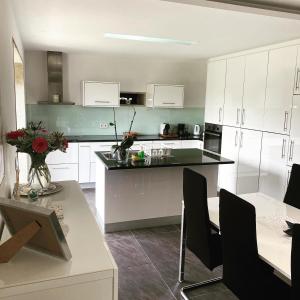 a kitchen with white cabinets and a black counter top at Serra de Arga Mountain House in Montaria