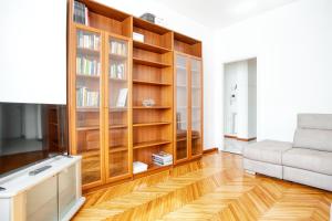 ein Wohnzimmer mit Bücherregalen aus Holz und einem Sofa in der Unterkunft JOIVY Cosy apt in the Giambellino area in Mailand