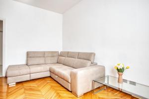 ein Wohnzimmer mit einem Sofa und einem Glastisch in der Unterkunft JOIVY Cosy apt in the Giambellino area in Mailand