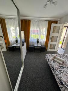 a mirror in a bedroom with a bed and a tv at Apartament in Orzysz