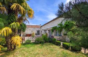 an exterior view of a house with palm trees at Domaine Chapelle in La Chapelle-la-Reine