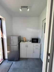 a small kitchen with a refrigerator and a microwave at Apartament in Orzysz