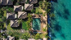 einem Luftblick auf ein Resort mit Pool und Meer in der Unterkunft Nirwana Beach & Resort in Candidasa