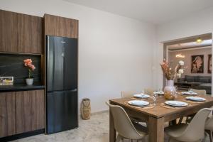 una cucina e una sala da pranzo con tavolo e frigorifero di Anastasia Luxury House a Afantou