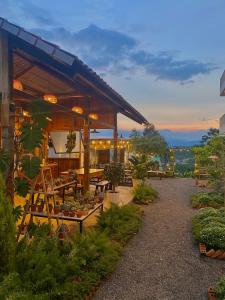 a building with a patio with tables and plants at Dứa Homestay in Bảo Lộc