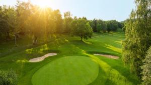 uma vista geral de um campo de golfe verde com duas tacadas em Golf Hotel Resort Du Val De Sorne em Vernantois