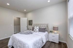 a bedroom with a large bed with a white bedspread at San Jose Shark House - Unit 2 in San Jose