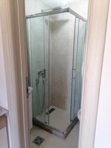 a shower with a glass door in a bathroom at Apartmani Perosevic in Danilovgrad
