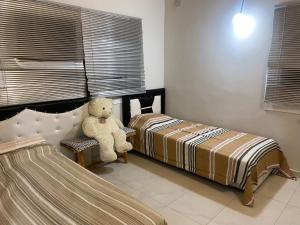 un orsacchiotto seduto su una sedia in camera da letto di Lane Palmiye a Samandağı