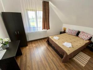 ein kleines Schlafzimmer mit einem Bett und einem Fenster in der Unterkunft Pensiunea Agroturistica Matis in Râșca