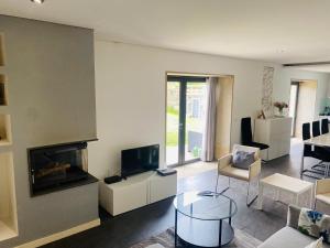 a living room with a fireplace and a tv at Serra de Arga Mountain House in Montaria