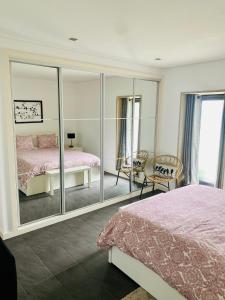 a bedroom with a mirror and a bed and a chair at Serra de Arga Mountain House in Montaria