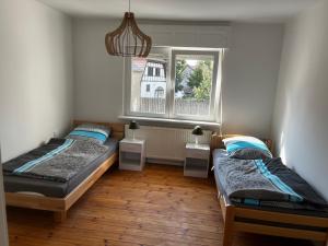 two twin beds in a room with a window at Große Monteurwohunung-Fewo in Trebbin