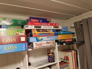 una pila de libros en un estante en una habitación en Charming beach house, en Moss
