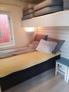ein kleines Bett in einem Zimmer mit Fenster in der Unterkunft Charming beach house in Moss