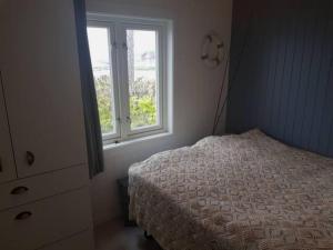 Schlafzimmer mit einem Bett und einem Fenster in der Unterkunft Charming beach house in Moss