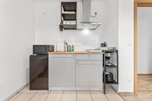 a white kitchen with a counter and a refrigerator at Helle moderne Wohnung, ,nahe Uni, zentral in Cottbus