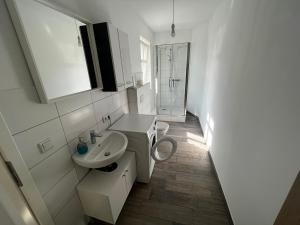 a white bathroom with a sink and a toilet at Große Monteurwohunung-Fewo in Trebbin