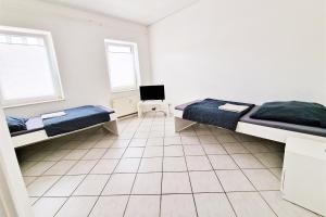 a bedroom with two beds and a tiled floor at Apartment with Roof-Top in Düren in Düren - Eifel