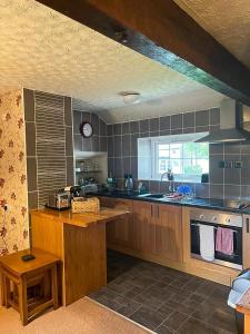 a kitchen with wooden cabinets and a counter top at Windale at Wetheral Cottages in Great Salkeld