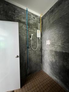 a bathroom with a shower with a hose on the wall at Koh Tao Little House in Koh Tao