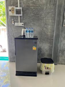 a small refrigerator with water bottles on top of it at Koh Tao Little House in Koh Tao