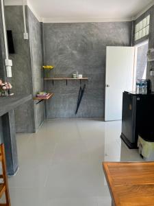 a living room with a white floor and a refrigerator at Koh Tao Little House in Koh Tao