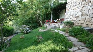 a garden with flowers in the grass next to a building at Pansion Villa Nur in Mostar