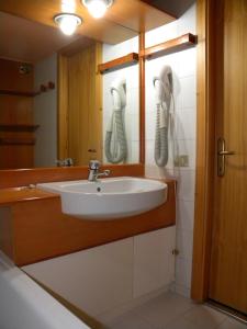 łazienka z umywalką i 2 telefonami na ścianie w obiekcie Residence Artuik Appartamenti Solandra w mieście Marilleva