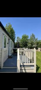 a porch of a house with a table and an umbrella at Tarka Holiday Park in Ashford