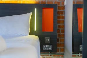 a bedroom with a bed with a clock on the wall at easyHotel Manchester in Manchester