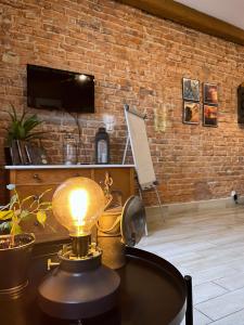 une lampe sur une table dans une pièce avec un mur en briques dans l'établissement Apartament Gwarek, à Wałbrzych