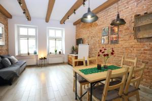 salon z ceglaną ścianą, stołem i krzesłami w obiekcie Apartament Gwarek w Wałbrzychu