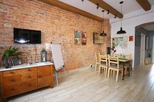a dining room with a brick wall and a table and chairs at Apartament Gwarek in Wałbrzych