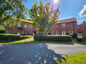 a brick house with a driveway in front of it at Windale at Wetheral Cottages in Great Salkeld