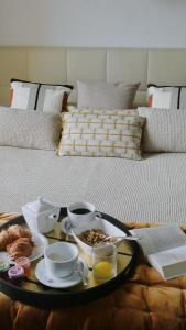 a tray of breakfast food on a table on a bed at Résidence & Hôtel Aria Marina in Propriano