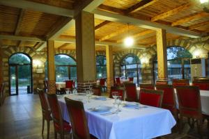 a dining room with a white table and chairs at Hotel Divna in Krumovgrad