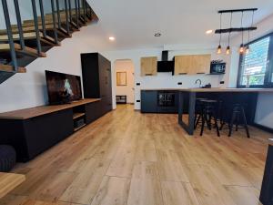 een open keuken en een woonkamer met houten vloeren bij Riverside Apartma 2, Kranjska Gora in Kranjska Gora